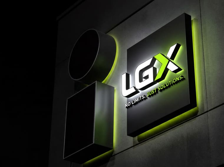 Illuminated channel letter sign mounted on a commercial storefront at night